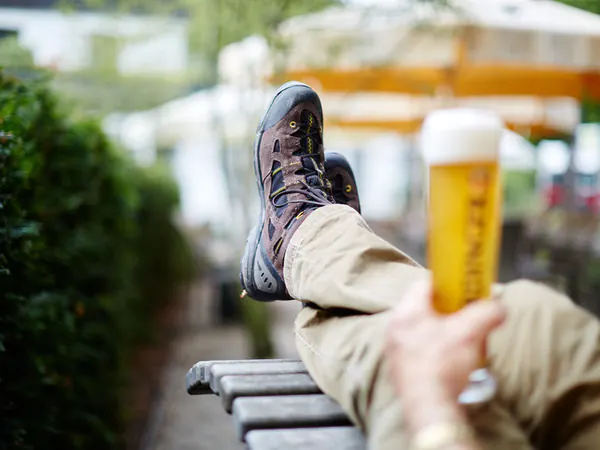 Wanderschuhe auf der Bank hochgelegt, dazu ein frisch gezapftes Bier im Biergarten