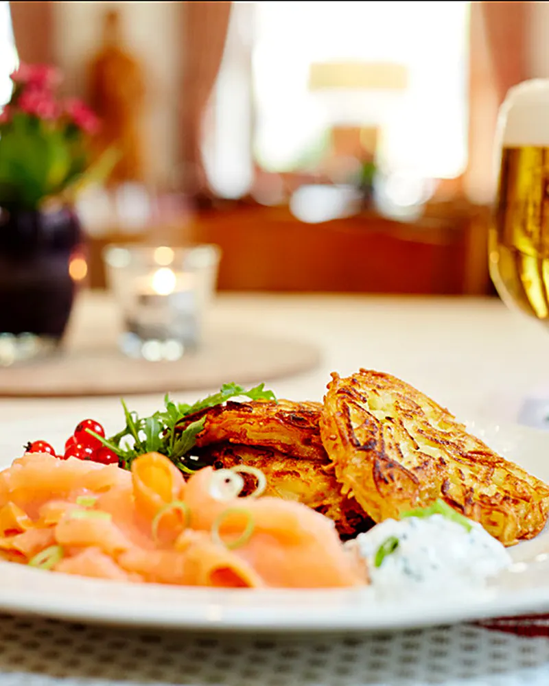 Räucherlachs auf Kartoffelrösti, dazu ein frisch gezapftes Bier