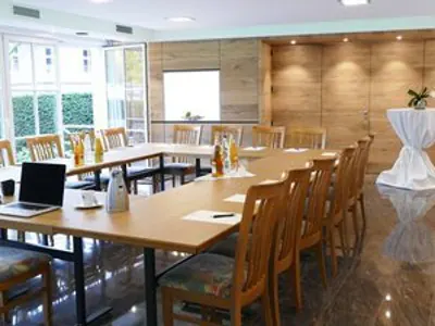 Tagungsraum in U-Form bestuhlt, mit Tageslicht und Leinwand