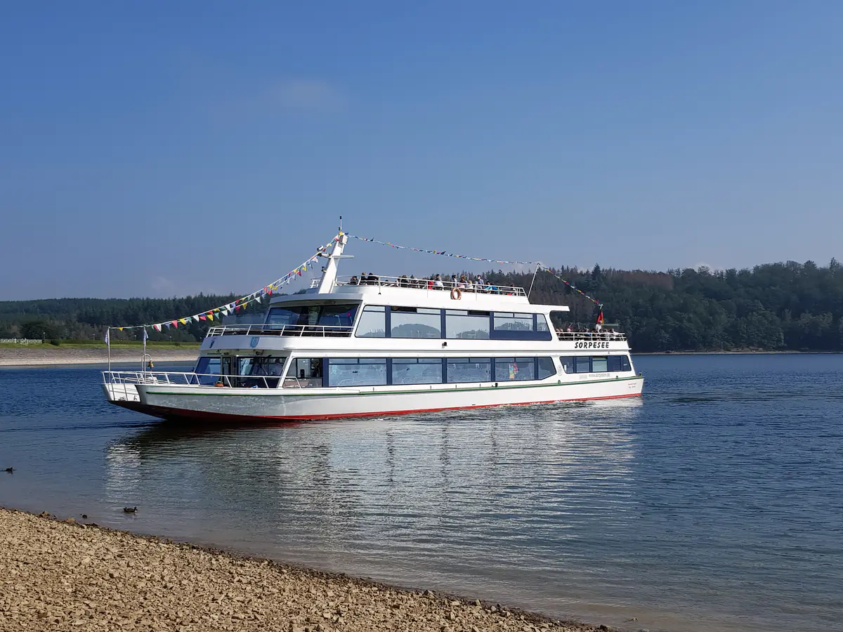 Das Fahrgastschiff MS Sorpesee vor dem Ufer der Sorpetalsperre