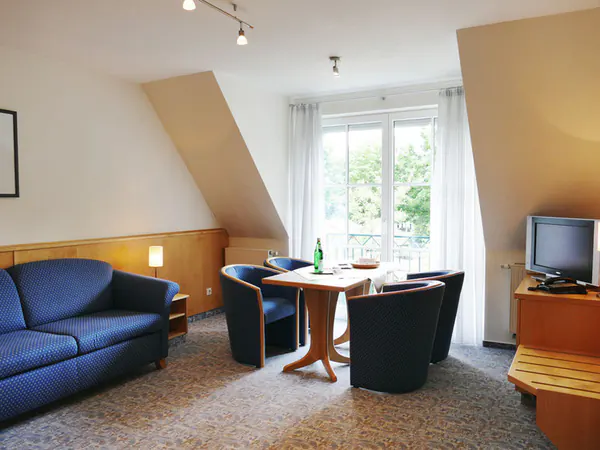 Wohnbereich des Zwei-Raum-Appartements mit Sitzecke und Landhausmöbeln