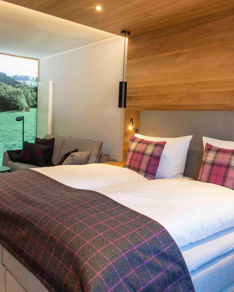 Doppelzimmer Rehberg Landhaus mit karierten Kissen und Boxspringbett
